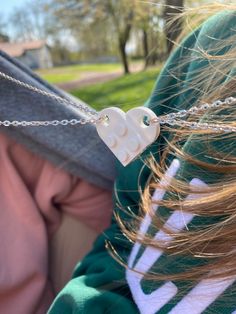 a close up of a person wearing a heart necklace