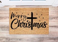 a door mat that says merry christmas with a cross in the center and stars on it