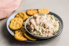 a bowl of chicken salad with crackers on the side