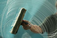 a person holding a piece of food in their hand with water droplets on the surface