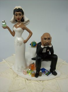 a bride and groom cake topper sitting next to each other