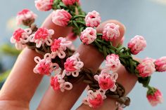 pink flowers are being held in the palm of someone's hand with their fingers