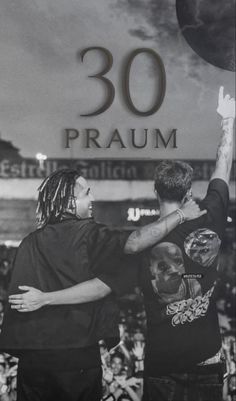 two men standing next to each other in front of a sign that says 30 praum