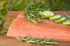 raw salmon with herbs and lemons on a cutting board