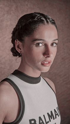 a woman in a tank top posing for the camera with her hair pulled back and eyes wide open