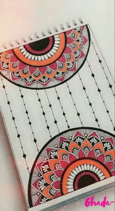 an open spiral notebook with designs on it