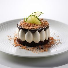 a white plate topped with a dessert covered in icing and garnishes