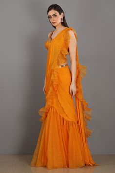 Orange frill chiffon skirt with organza ruffle drape. Comes with silk embroidered blouse and belt.
Component: 4
Embroidered
Neckline: Sweetheart
Sleeve Length: Sleeveless
Fabric: Chiffon, Organza, Silk
Color: Orange
Embroidered blouse and belt
Separate ruffle drape - Aza Fashions Elegant Organza Pre-draped Saree With Ruffles, Elegant Pre-draped Ruffled Organza Saree, Elegant Georgette Pre-draped Saree With Ruffles, Chiffon Pre-draped Saree With Ruffles, Fitted Organza Pre-draped Saree With Ruffles, Traditional Ruffled Organza Gown, Wedding Silk Chiffon Dress With Ruffles, Silk Pre-draped Saree With Ruffles For Wedding, Party Georgette Pre-draped Saree With Ruffles