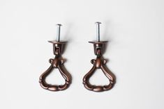 two pairs of metal hooks on a white background