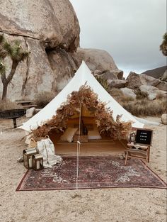 a tent set up on top of a rug in the desert