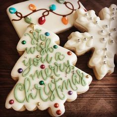 decorated christmas cookies sitting on top of a wooden table