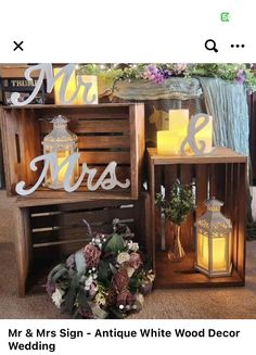 two wooden crates filled with candles and some flowers on top of each other in front of a sign that says mr & mrs antique white wood decor