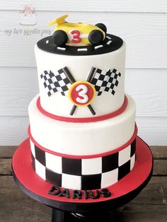 a three tiered cake decorated with race cars