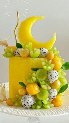 a cake with fruit on it and the moon in the background