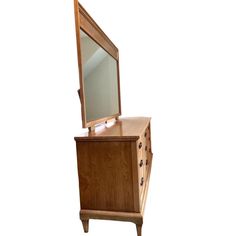 a wooden dresser with a mirror on it's top and drawer underneath the mirror