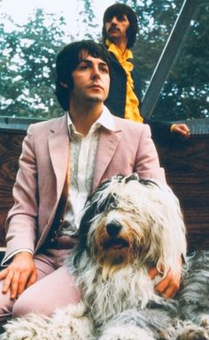 a man sitting next to a shaggy dog