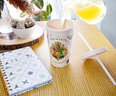 a coffee cup is being poured into a paper cup with a notepad on the table