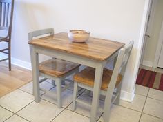 a kitchen table with two chairs and a bowl on it