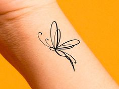 a small black butterfly tattoo on the left wrist and right arm, with an orange background