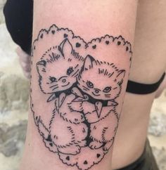 a woman with a tattoo on her arm has two cats in the shape of a heart