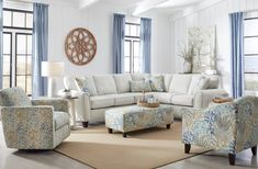 a living room with white furniture and blue curtains