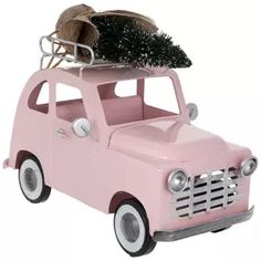 a pink toy truck with a tree on the roof and luggage strapped to it's back