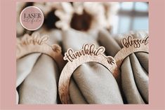 two wooden name rings sitting next to each other on top of a table with flowers in the background