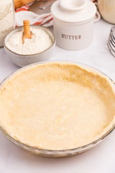 an uncooked pie sitting on top of a table next to other baking supplies