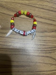 "Relive all the fun and excitement of the hit Hero anime with this Hawks inspired beaded bracelet. It features the phrase \"Baby Bird\" paired with a mix of red, brown, and gold plastic and glass beads. It is accented with two feather charms. They are secured on a elastic cord that is available in your choice of lengths: 7, 7.5, 8, 8.5, or 9\", to ensure a perfect fit." Hero Anime, Bird Bracelet, Kandi Bracelets, Anime Inspired Outfits, Diy Bracelets Patterns, Red Feather, Loom Bands, Wing Necklace, Baby Bird