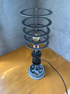 a lamp made out of gears on a wooden table