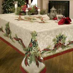 a christmas table cloth with holly and poinsettis on it in front of a fireplace