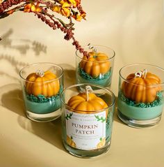 three glass cups filled with pumpkins on top of a table