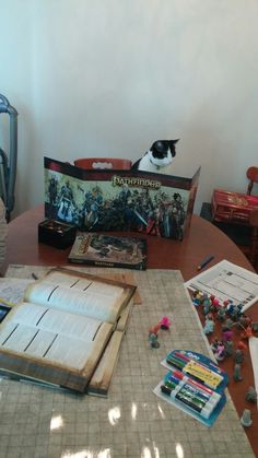 an open book sitting on top of a wooden table next to toy figurines