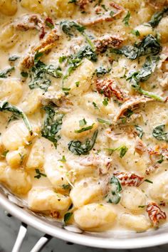 a pan filled with pasta and spinach covered in cheese