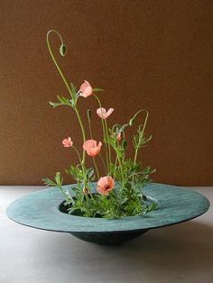 a blue bowl with some pink flowers in it