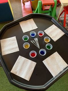 the child is playing with their art project on the table in the playroom at school