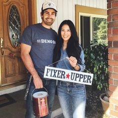 a man and woman standing in front of a house holding a sign that says fixer upper