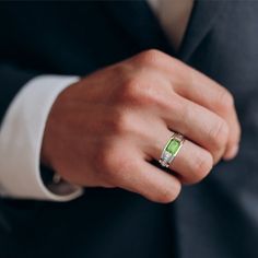 a man in a suit and tie wearing a ring with an amethorate stone