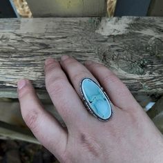 "With A Head Full Of Snow" Soft cornflower blue with a gorgeous pattern, this Gobi Desert Lavender Turquoise cabochon is set in fine and sterling silver, with a cutout sterling border. Oxidized and tumbled for a satin finish. Sterling silver split shank band. The stone setting measures approximately 34mm tall by 16mm wide. Size 6.5 US Unique Turquoise Larimar Ring, Unique Turquoise Larimar Gemstone Ring, Blue Larimar Cabochon Rings, Oval Silver Larimar Turquoise Ring, Handmade Blue Turquoise Larimar Ring, Handmade Oval Larimar Turquoise Ring, Artisan Blue Turquoise Ring Stamped 925, Artisan Turquoise Ring Stamped 925, Turquoise Larimar Ring As Gift