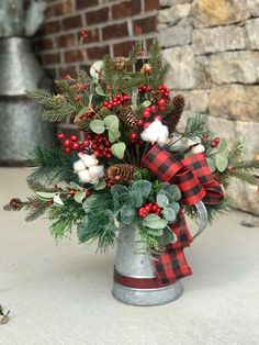 a christmas arrangement in a metal watering can