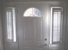 a white front door with two windows and shutters