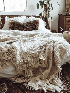 an unmade bed with white blankets and pillows