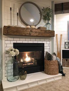 a fireplace with a mirror above it and a basket on top of the fire place