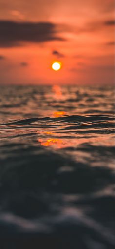 the sun is setting over the ocean as it reflects in the water's surface