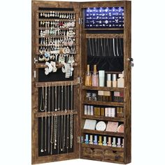 an open wooden jewelry cabinet filled with lots of necklaces