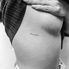 a woman's stomach with the word love tattooed on her lower side ribcage