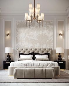 a large bed sitting in a bedroom under a chandelier next to two lamps