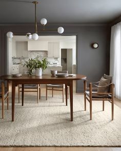 a dining room table with chairs and a potted plant on top of the table