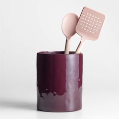 two utensils sticking out of a purple cup