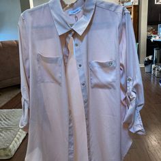 This Is A Dusty Rose Calvin Klein Blouse. Can Be Worn With The Sleeve Either Rolled Up Or Full Length. Full Length Of Sleeve Equals 25 Inches Under Arm To Under Arm When Blouse Is Buttoned Equals 22 1/2 Inches. There Are Eight Buttons On The Front Placket. From Under Arm To The Side Him Equals 12 1/2 Inches. The Length Of The Shoulder To The Fulham Equals Inches 30 1/2 Inches. Trendy Calvin Klein Tops For Spring, Spring Calvin Klein Button-up Tops, Calvin Klein Button-up Tops For Spring, Calvin Klein Spring Button-up Tops, Calvin Klein Summer Button-up Top, Calvin Klein Long Sleeve Spring Shirt, Calvin Klein Collared Top For Work, Spring Calvin Klein Tops For Workwear, Calvin Klein Long Sleeve Shirt For Spring